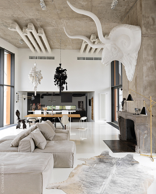 The living room is united with the dining space and kitchen and features an oversized animal head sculpture