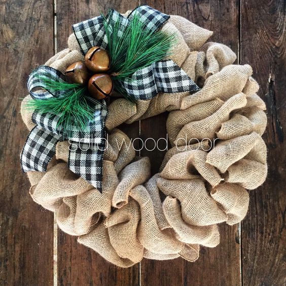 A burlap wreath with a buffalo check bow, jingle bells and faux pine needles