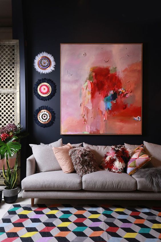 the artwork not only fits the space but also echoes with colorful pillows