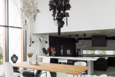 The dining space is done in black and white, with mismatching chairs and unique chandeliers