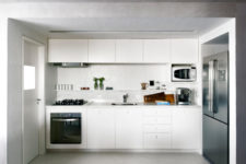 05 The kitchen is done in white, with a different floor and lower ceiling to visually separate it from the rest of the space