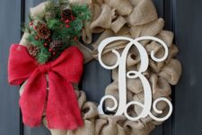05 a burlap wreath with a monogram, a red bow and evergreens and pinecones for a chic look