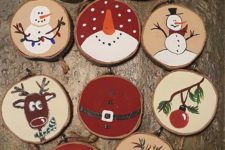 05 various painted wood slice ornaments that include snowmen, stockings, deer and trees