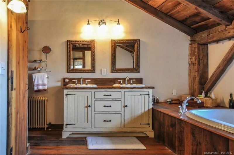 The bathroom is clad with wood, even the bathtub and there's a vintage vanity