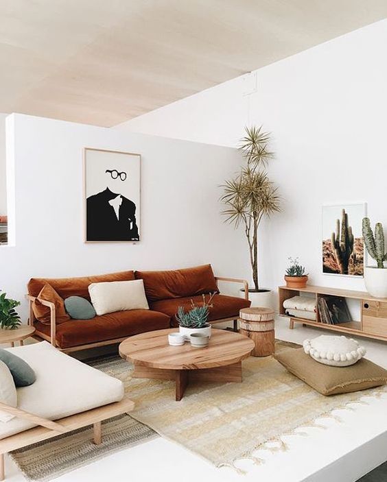 a Japandi living room with whites and light-colored wooden furniture, cognac textiles and sades of green for a cool look
