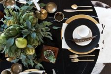 06 a black table, black and gold plates, a lush greenery, veggies and pears centerpiece
