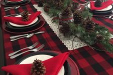 06 a plaid tablecloth, red napkins and lots of pinecones and evergreens for a rustic tablescape