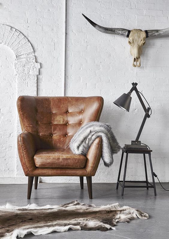 a comfy brown leather armchair plus metal items  for an industrial interior
