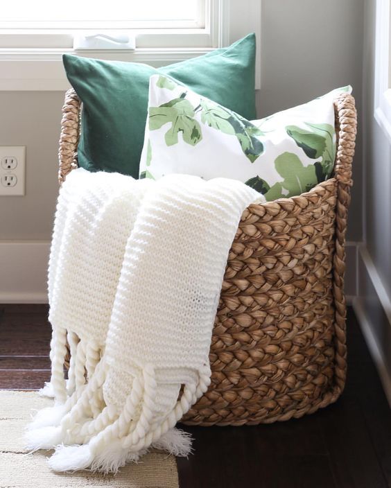 a large basket with blankets and pillows is ideal for a bedroom