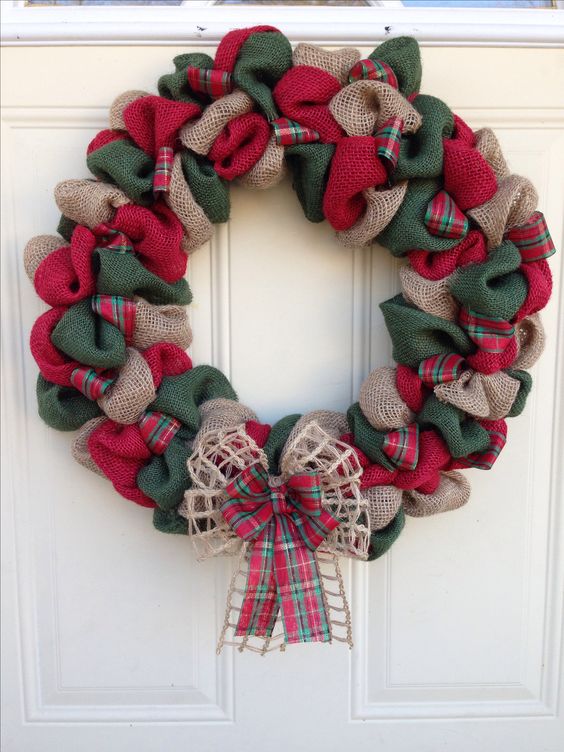 A traditional red, green and neutral burlap wreath with a double bow for a front door