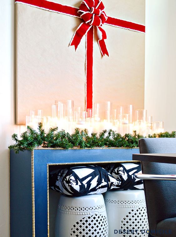an evergreen garland, lots of candles and a gift artwork over the console look super chic