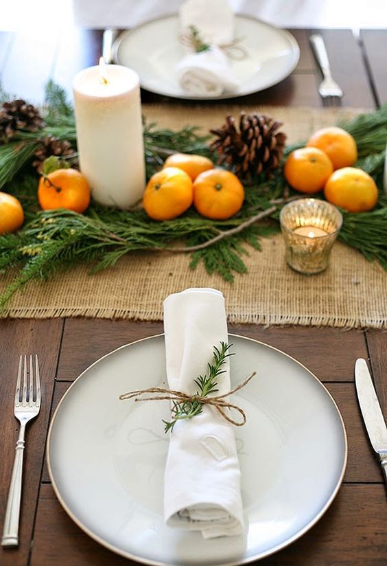 a burlap table runner, citrus, pinecones and candles are great for a rustic tablescape