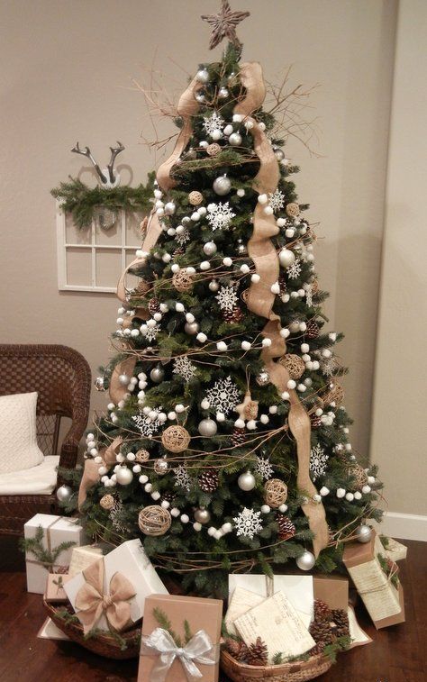 A chic Christmas tree decorated with silver snowflakes, pompoms, pinecones and burlap ribbons