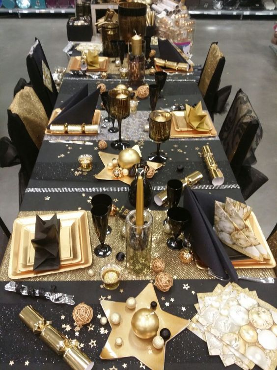 a fun black and gold tablescape with stars, stripes and candles is amazing for a New Year's Eve