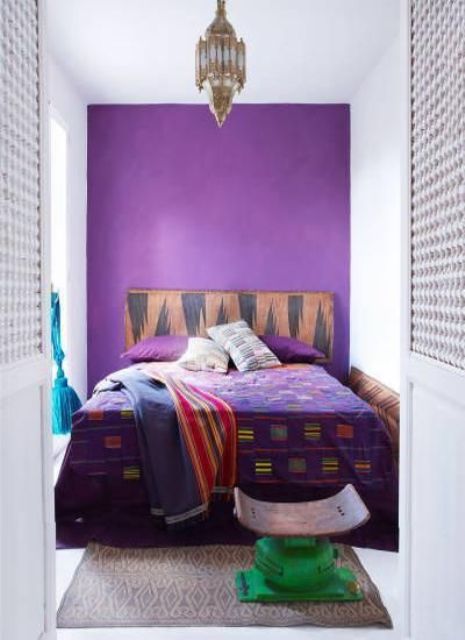 a violet wall for a statement in the bedroom and matching bedding for a bold look
