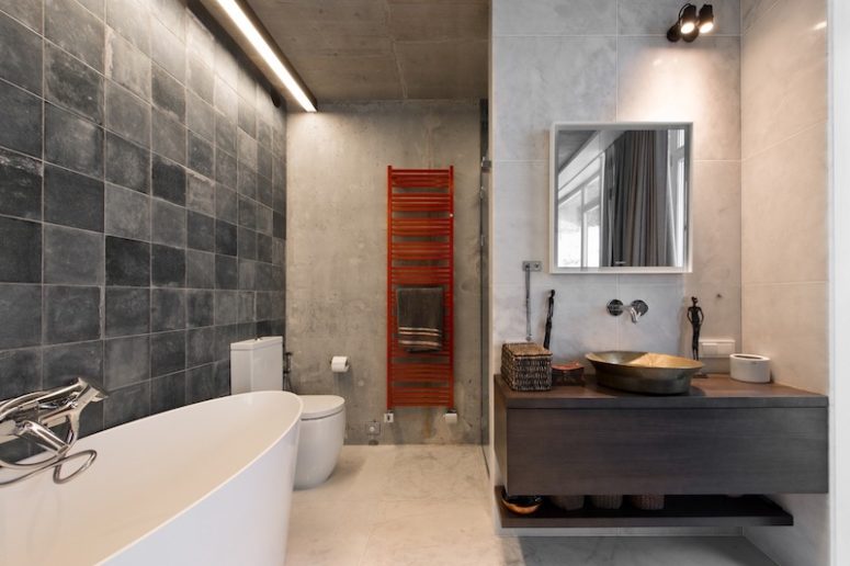A red radiator reminds of the rugs in the bedroom, and concrete-like tiles add a modern touch here