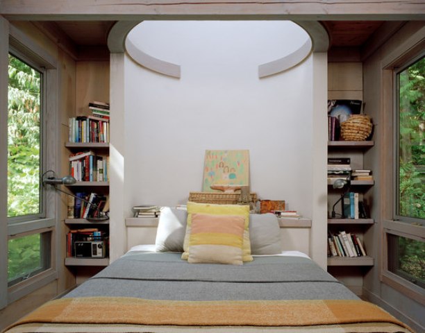 The master bedroom features bookshelves on both sides and a skylight above the bed