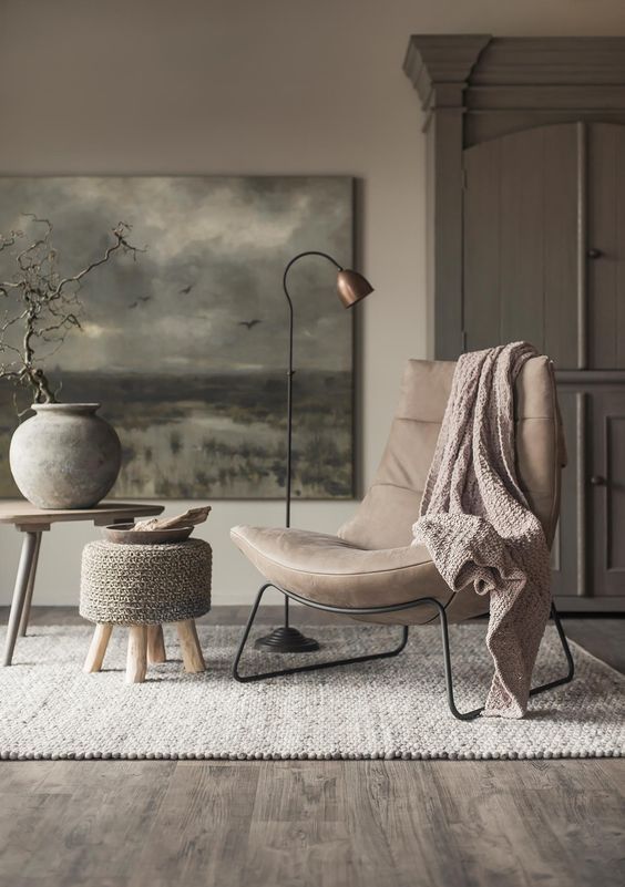 a chic beige leather modern chair on metal legs and a metal floor lamp for a chic reading nook