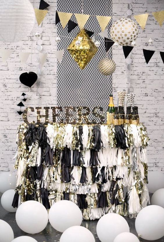 a cheerful black and silver sparkly fringe bar cart with a sign and lights and balloons around