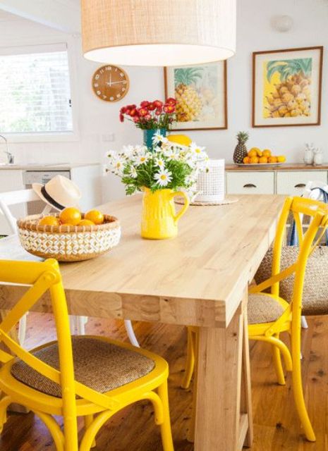 yellow chairs and colorful artworks will spruce up the kitchen and make it cheerful