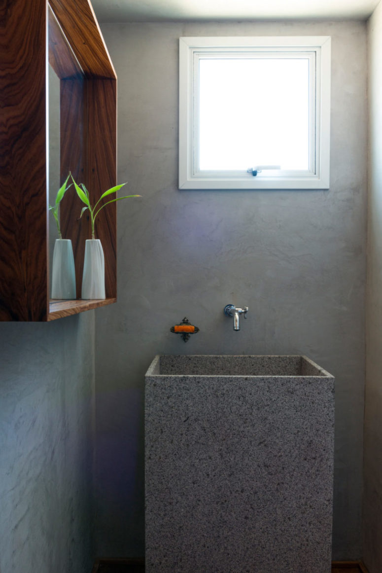The bathroom is done with concrete, with stone and wood
