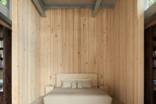 11 The guest bedroom is clad with natural wood and there’s an upholstered creamy bed