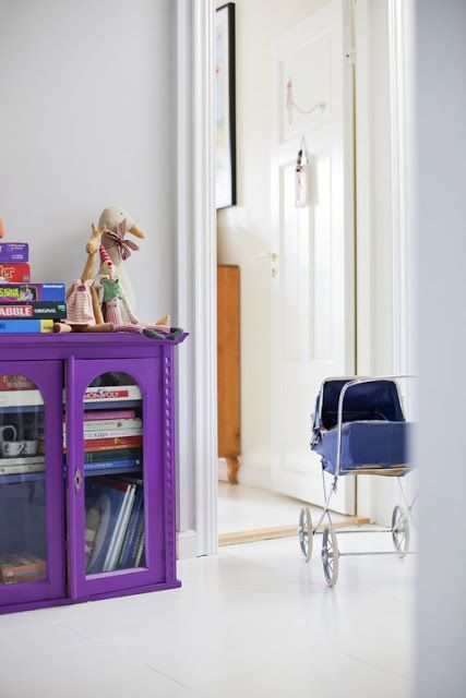 a bold violet bookcase placed right on the floor is a cool idea for any space