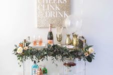 11 a chic bar cart decorated with a greenery garland and blooms and gold pineapple ice holders