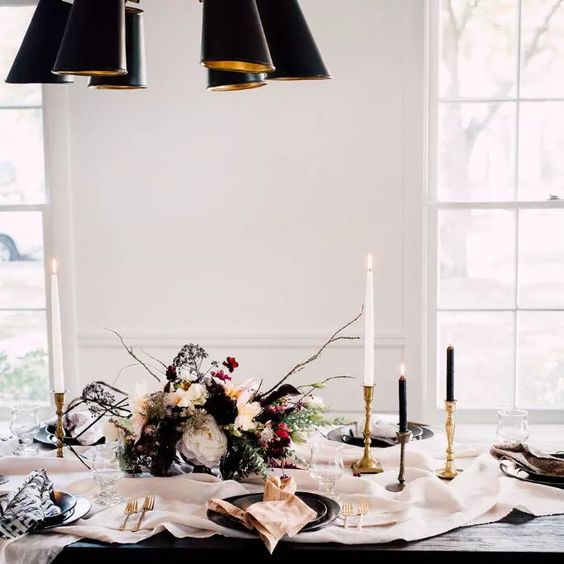 a chic black and white tablescape with gold touches, a textural bloom centerpiece and black plates, a neutral table runner