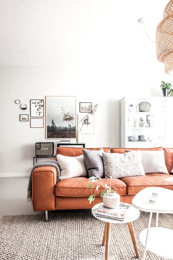 An apricot colored faux leather sofa looks chic, modern and vivacious plus adds a colorful statement