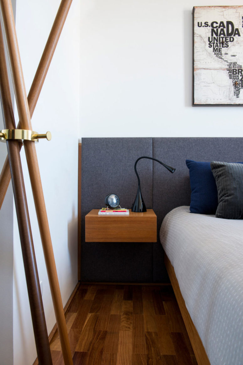 The bedroom shows off an upholstered headboard, a floating bed and nightstands