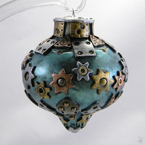 a metal Christmas ornament with metal stars, gears, grommets and other details