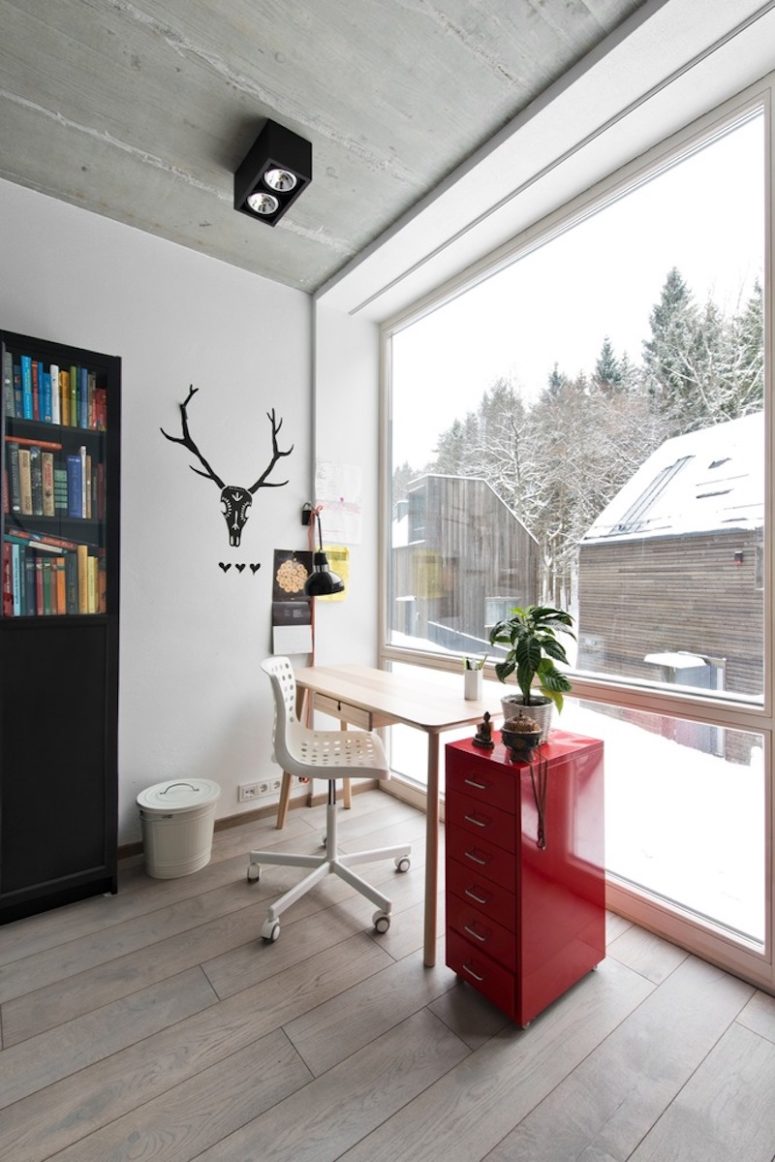 The home office features red and black touches and a large window to enjoy the views