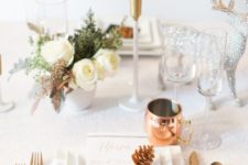 13 a chic holiday tablescape with white blooms, copper cutlery and mugs and a silver deer figurine for a sparkly touch