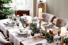 14 a chic neutral tablescape with candles, evergreens, deer figurines, faux birds and branches