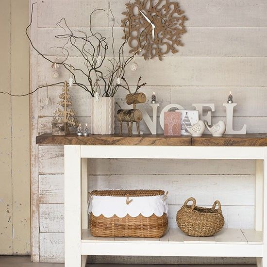 a rustic console with wooden and wicker decor, with letters and bracnesh in a cable knit vase