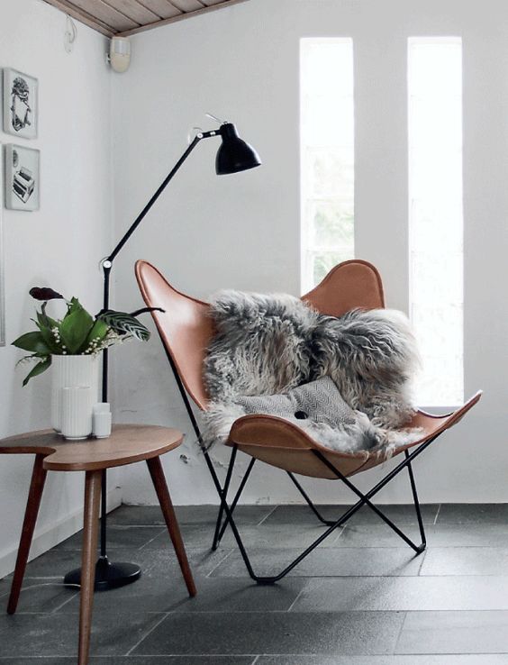 a very chic leather chair with faux fur and a Scandinavian floor lamp for a stylish reading nook