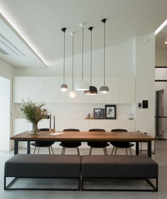 minimalist white cabinets and a stained dining table plus upholstered benches for a chic space