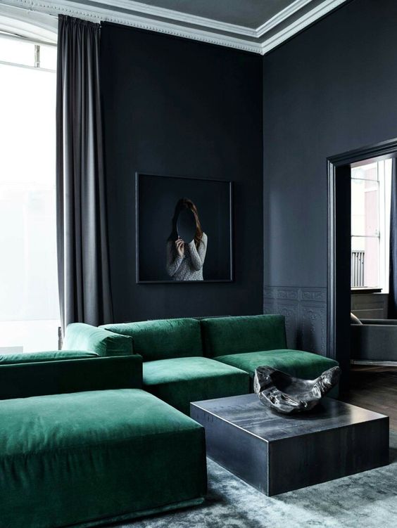 two mistakes in one room, black walls and a too large sofa steal the whole space