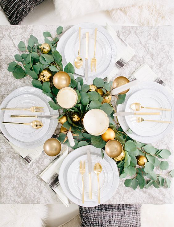 a lush foliage table runner with fold ornaments and gold goblets for a simple and elegant look