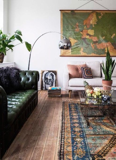 a dark green tufted leather sofa for a boho room with lots of greenery in pots