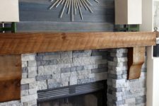 17 a faux stone clad fireplace with a wooden mantel and dark stained reclaimed wood over the mantel