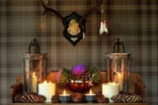 17 large pinecone, candles an candle lanterns with antlers over the console for a woodland-inspired space