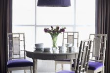 17 violet upholstered chairs and a matching wicker pendant lamp over the table