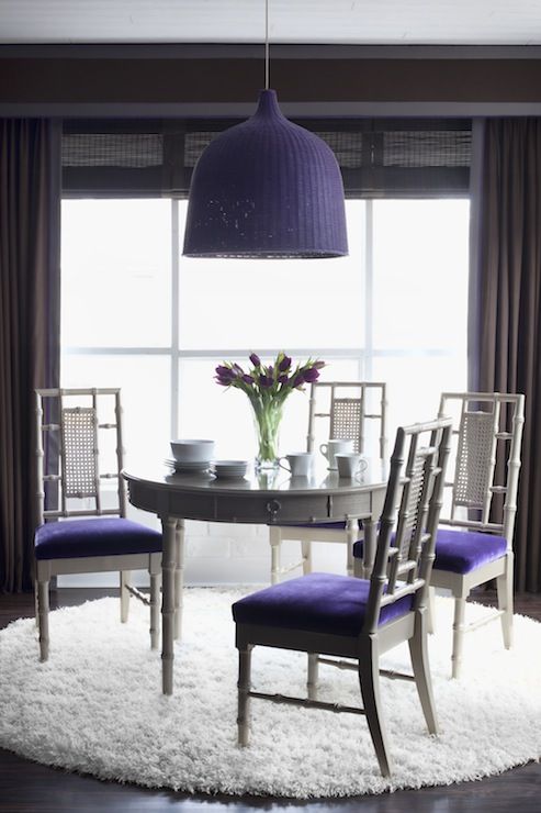 violet upholstered chairs and a matching wicker pendant lamp over the table