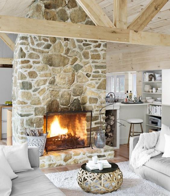 a gorgeous stone fireplace in light shades with a metal cover looks very genuine