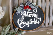 18 a raw edge wood slice chalkboard Christmas sign with pale millar, a striped ribbon and some berris