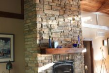 19 a rustic stone clad fireplace with a wooden mantel surrounded with candles