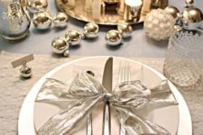 19 a shiny table setting with silver ornaments, mercury glass candle holders and candles