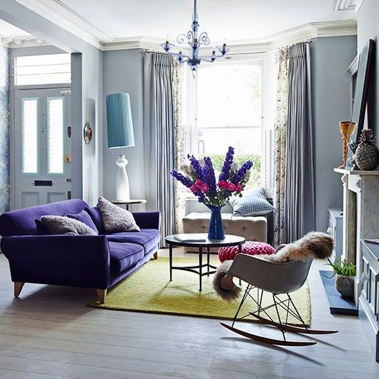 a violet upholstered sofa and a matching chandelier will add color to the space